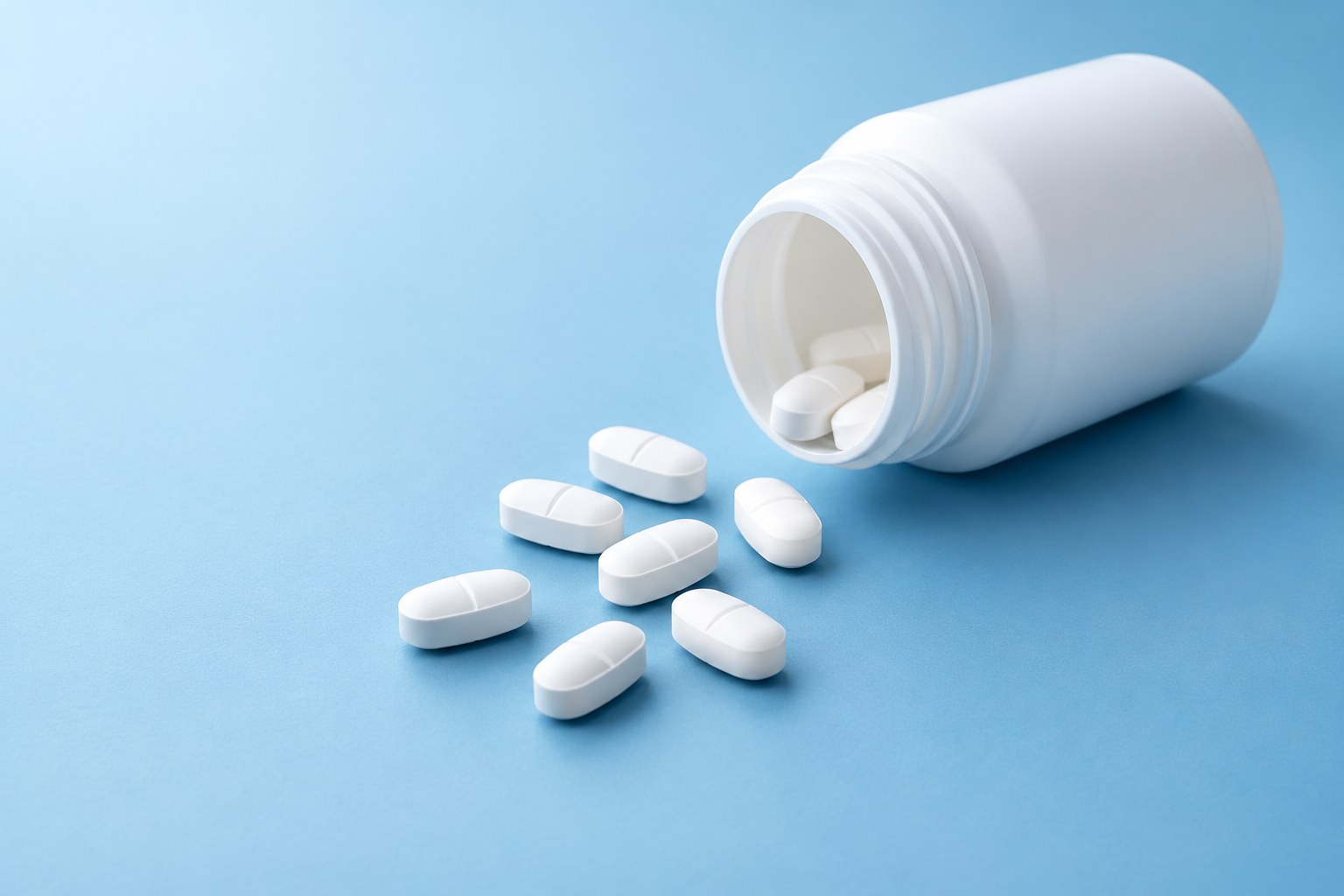 Unlabelled white bottle with tablets, illustrative pharmacy photography
